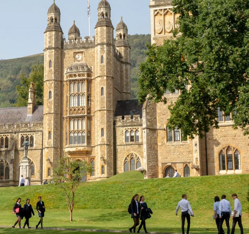 Students walking past the traditional architecture of Malvern College.