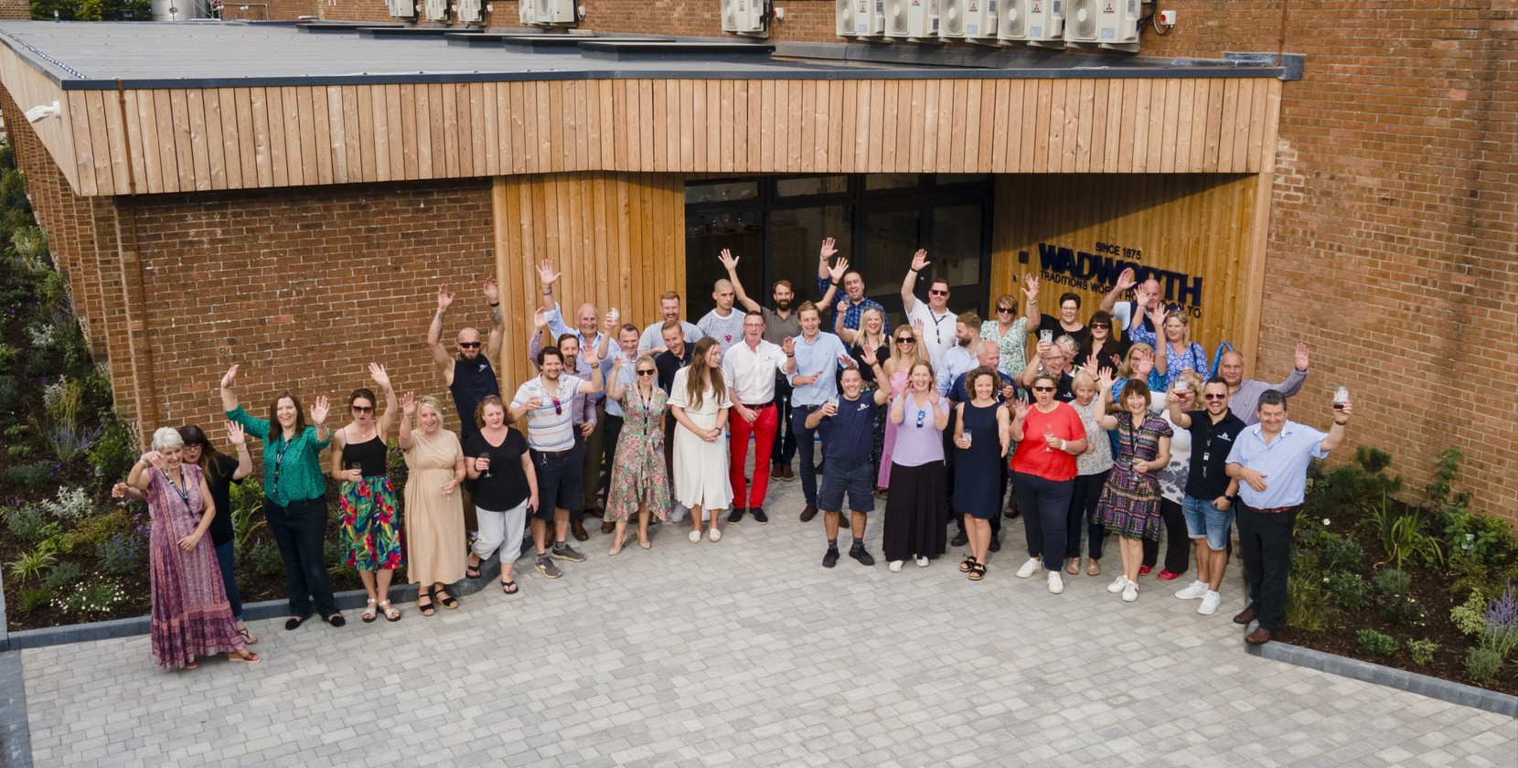 Close-up of six craft beer cans displayed on a wooden surface, featuring colourful designs and branding. Visible labels include Wadworth Henry’s IPA in red, Horizon in cream, 6X Original Ale in blue, Folly Road Evolution Session IPA in teal and red, To Helles and Back in white with bold stripes, and Corvus Milk Stout in black with a crow illustration. Background shows shelves stocked with more cans.
